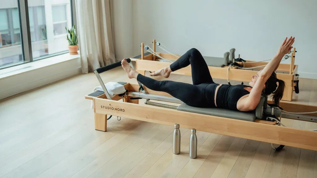 Pilates reformer workout emphasizing core stability and spinal support in structured exercise setting