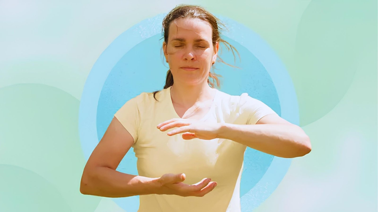 Woman in yellow shirt with eyes closed holds Tai Chi "Ball of Energy" pose against pastel graphic background.