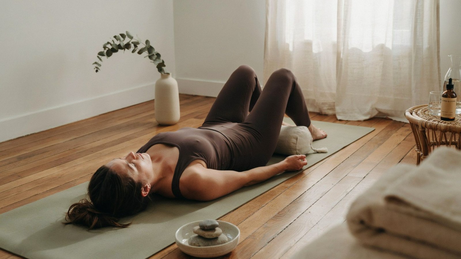 Relaxed person lying on mat in restorative yoga pose for back pain relief and stress reduction